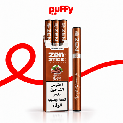 A box and single disposable vape pen of Puffy b2b Zen Stick in Secret Coffee flavor, shown on a white background with a red ribbon graphic and Arabic warning label.